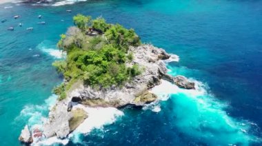 Deniz sörfü ve dalgalar kayalık kayalıklardaki açık delikten geçer. Kristal koy küçük adası kayalık uçurum kıyısı Nusa Penida adası, Bali, Endonezya