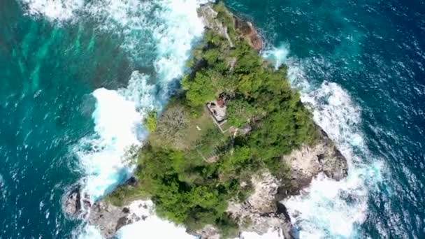 Περιστρεφόμενη εναέρια κλιπ drone των κυμάτων σύνθλιψη στα βράχια. Μικρό νησάκι καλυμμένο με πουλιά από ψηλά. Εναέρια βολή με αργό ζουμ και περιστροφή — Αρχείο Βίντεο