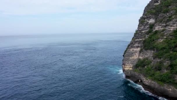Drone vlucht rond een hoge rots klif. Cinematische luchtfoto van Tropisch eiland met turquoise watergolven verpletterende rotsachtige boog — Stockvideo