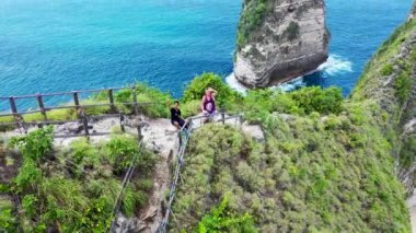İki Karışık Yarış Turisti Arka planda İnanılmaz Kelingking Sahili ile Komik Selfie Uçağı Videosu Çekiyor. Nusa Penida, Endonezya. Uluslararası arkadaşlık. 4K