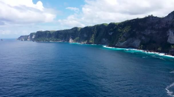 Skalistý útes pobřeží a oceánské vlny letecký výhled na ostrově Nusa Penida, Bali, Indonésie. Blue Water, Mountain Cliff, Waves, Rocks, Beautiful Ocean — Stock video