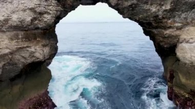 Kingfisher, Endonezya 'nın Nusa Penida Adası açıklarındaki Batu Madeg' in uçurumundaki bir delikten uçuyor. Dev kaya Batu Batumelawang 'dan uzaklaşarak geniş bir alana yayıldı