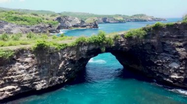 Endonezya 'da, Nusa Penida' da okyanusun üzerinde kaya kemerinin üzerinden uç. Yüksek kalite 4k görüntü