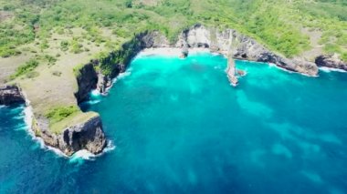 Endonezya 'nın Nusa Penida adasındaki ünlü sahil turistik bölgesinin kıyı şeridine çarpan turkuaz okyanus dalgaları.