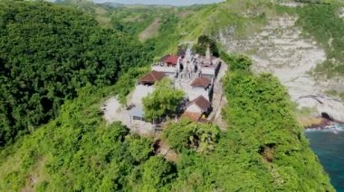 Tanjung Gunungcemeng tepesindeki Hindu tapınağı. Tropikal manzarada hava manzarası. Arka planda gök mavisi plajlar ve güneşli bir günde Hint okyanusunun berrak suları.