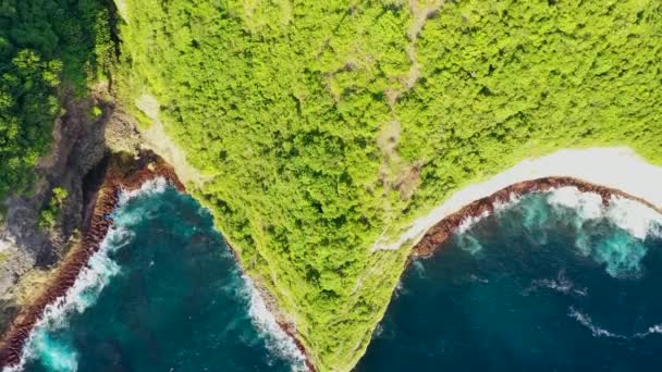 垂直の崖の上に建てられたYYY寺院でインドネシアのヌサペニダの西海岸の映像を上に傾け、小さな道が端に向かっています — ストック動画