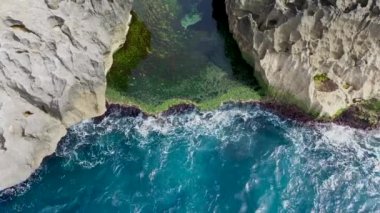 Endonezya 'daki Nusa Penida Adası' ndaki kayaların arasındaki doğal havuz Melekler Billabong 'u. Yüksek kalite 4K hava kuşlarının göz görüntüsü