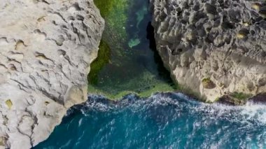Genç bir çift Billabong 'un doğal havuzunda öpüşüyor. Meleklerin gölgesinde uçarak uçan insan, güneşi uçurumlara doğru eğiyor.