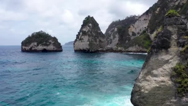 Fliegen Sie um Klippen und Felsen über den Ozean entlang der Küste mit atemberaubender Aussicht auf Diamond Beach, Nusa Penida, Bali, Indonesien. Hochwertiges 4k-Luftbild — Stockvideo