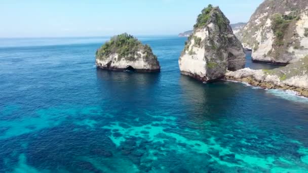 Aérea avanzando sobre el océano y las montañas en la playa Diamond, Nusa Penida, Bali, Indonesia. Hermosa agua azul azur. Famoso lugar turístico — Vídeos de Stock