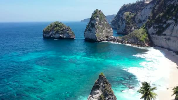 Inclinação aérea para baixo vista do oceano e montanhas na praia Diamond, Nusa Penida, Bali, Indonésia. Bela água azul azure. Famoso lugar turístico — Vídeo de Stock