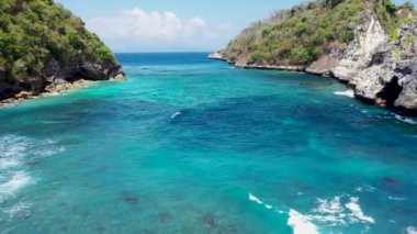 Diamond Beach, Nusa Penida, Bali, Endonezya 'nın muhteşem manzarasıyla okyanus boyunca uçurumun ve kayaların üzerinden uçmak. Yüksek kalite 4K hava görüntüsü