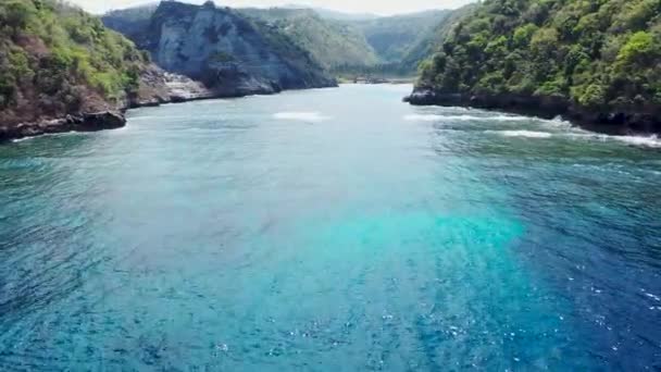 Volare intorno a scogliera e rocce sopra l'oceano lungo la costa con vista mozzafiato su Diamond Beach, Nusa Penida, Bali, Indonesia. Filmati aerei 4k di alta qualità — Video Stock