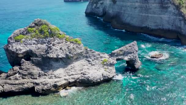 Съемка с воздушного беспилотника потрясающего пляжа Атух в Нуса Пенида на Бали, Индонезия. Остров славится своими впечатляющими скалами и ландшафтом — стоковое видео
