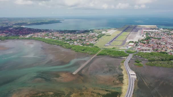 バリ島の国際空港から離陸する航空機のドローンの商業航空機の映像。航空会社のジェットがスピードアップし、地元空港で空に上昇 — ストック動画