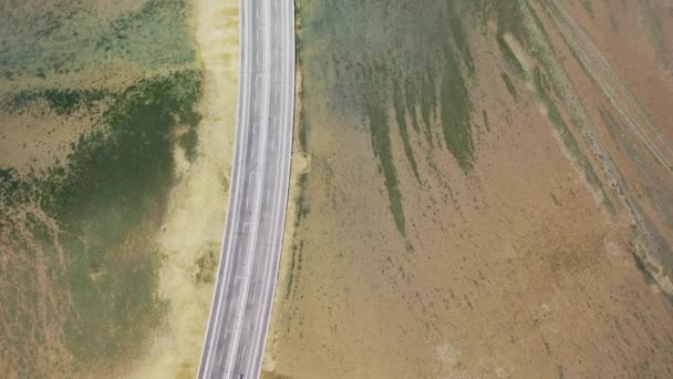 Vista aérea de Bali Mandara pedágio estrada sobre o mar na ilha de Bali. Carro, ponte de moto através do Golfo de Benoa conectando a cidade de Denpasar e Kuta do Sul, Nusa Dua e Aeroporto Internacional Ngurah Rai. — Vídeo de Stock