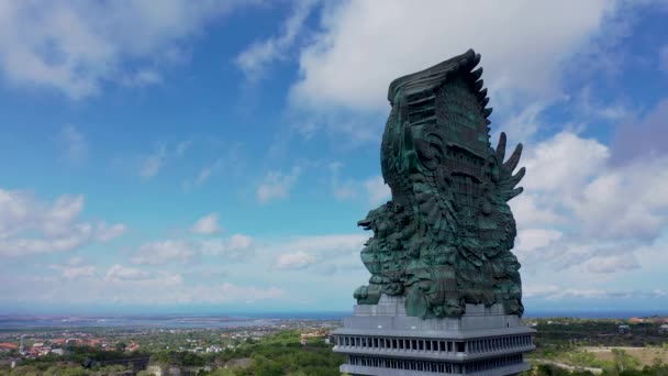 Boczny widok z lotu ptaka giganta Garuda Wisnu Kencana na Bali w Indonezji. Posąg Garudy ujeżdżany przez Wisznu wznoszący się nad miastem — Wideo stockowe