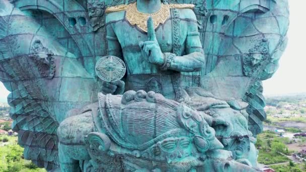 Das Gesicht der Hindu-Gottheit Vishnu in der Statue Garuda Wisnu Kencana auf Bali, Indonesien. Nahaufnahme Luftaufnahme religiöser Figur auf großer Kupferstatue über der Stadt — Stockvideo
