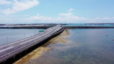 Alçak gelgit sırasında Bali geçidi boyunca alçak insansız hava aracı uçuşu. Sanur, Nusa Dua ve uluslararası havaalanını birbirine bağlayan modern deniz otoyolu.