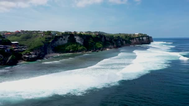Dron létat podél útesu Uluwatu s modrým oceánem a zataženou oblohou na Bali Indonesia. Působivý výhled. Vysoce kvalitní letecké 4k záběry — Stock video