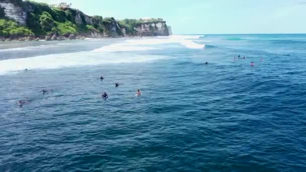 Flygfoto över havet stenig kust med surfa vågorna, Bali, Indonesien, Pura Uluwatu klippa. Vågor krossar stenig strand. Hav med vågor och stenig klippa. Havslandskap, klippor, hav. 4K-video. Resebegrepp — Stockvideo