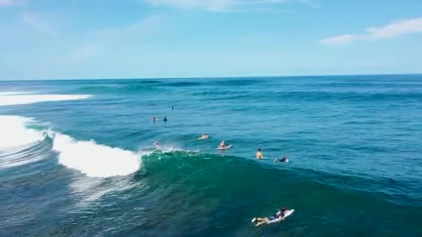 Uluwatu, Bali, 15 de octubre de 2021. Vista aérea de surfistas esperando grandes olas, en Bali. drone shot de surfistas sentados en sus tablas de surf y esperando la próxima ola — Vídeo de stock