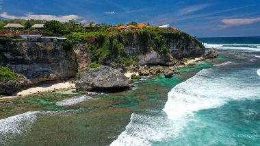 Kıyı şeridi ile harmanlanmış birkaç otel binasıyla yeşil uçurumların güzelliği..