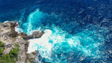 Dalgaların hava görüntüsü Crystal Bay plajı Nusa Penida, Bali 'deki kayalara çarptı..