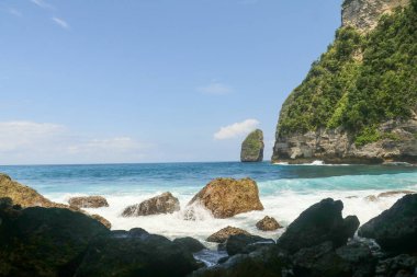 Dalgaların portresi kayalara çarpıyor ve su sıçratıyor..