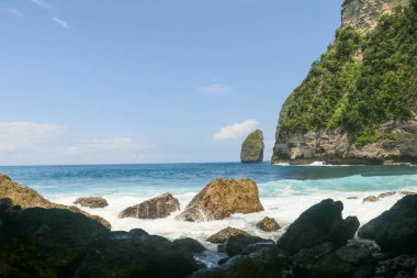 Dalgaların portresi kayalara çarpıyor ve su sıçratıyor..