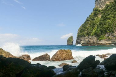 Dalgaların portresi kayalara çarpıyor ve su sıçratıyor..