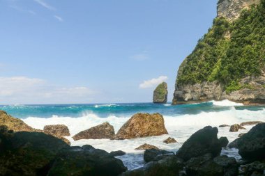 Dalgaların portresi kayalara çarpıyor ve su sıçratıyor..