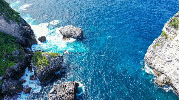 View from above the calm blue sea and the rocks.