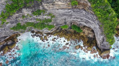 Yeşil uçurumların ve mavi denizin havadan görünüşü.
