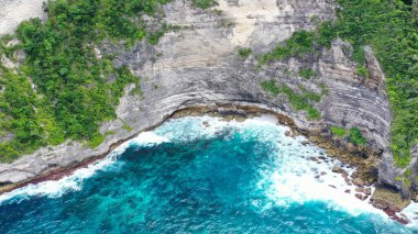 İnsansız hava aracı tarafından çekilen güzel mavi okyanuslu yeşil uçurumların manzarası.