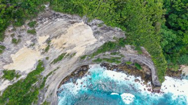 Yeşil uçurumların ve mavi denizin havadan görünüşü.