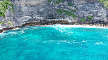 Nusa Penida uçurumlarının parlak mavi denizi insansız hava aracı tarafından çekilen görüntüsü.