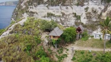 Ağaç Evi 'nin merdivenlerinde duran bir turist. Rumah Pohon, Atuh Sahili, Nusa Penida, Bali, Endonezya