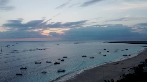Gyönyörű naplemente a tengerparton a Jimbaran falu sziluettek emberek. Bali, Indonézia — Stock videók