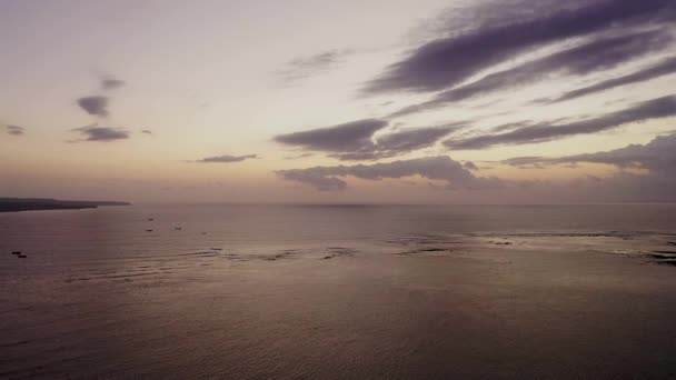 Úžasný západ slunce na jedné z nejdelších pláží na Bali - Jimbaran Beach, Bali, Indonésie. V tomto videu můžete vidět malé vlny, barevné nebe — Stock video