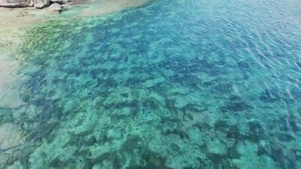 Azurblauer Strand mit felsigen Bergen und klarem Wasser des Indischen Ozeans am sonnigen Tag. Blick auf eine Klippe am Strand von Balangan, Bali, Indonesien — Stockvideo