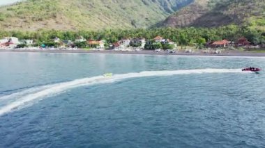 Motorlu tekne, iç veya arka tampon olarak bilinen şişirilebilir tüpte oturan insanları çekiyor. Ekstrem su sporları yapıyor.