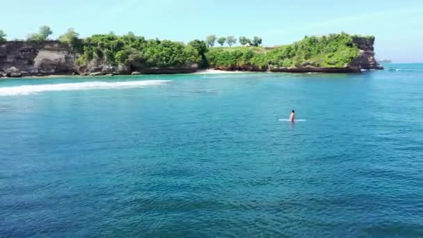 Vuelo dinámico de panoramización de drones aéreos de 4k sobre surfistas en trajes de neopreno esperando buenas olas en la mundialmente famosa Balangan Beach, Indonesia. Un famoso destino turístico en Bali — Vídeos de Stock