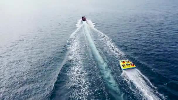 Barco de banana inflável dos peixes voadores dos tubos amarelos da venda que voa rebocáveis para esportes da água, praia de Taino, Bahamas — Vídeo de Stock