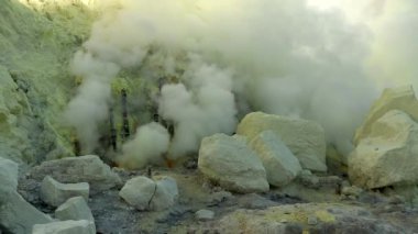 Sülfür madeninin sinematik hava görüntüsü Endonezya 'nın Doğu Java bölgesindeki Kawah Ijen volkanı kraterine zehirli sülfür gazı bulutları saçıyor.