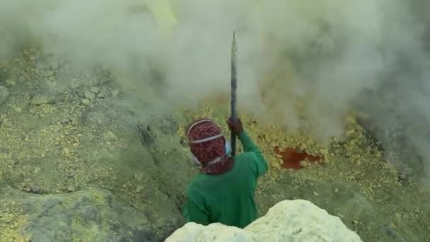 Sulfur miner extracting sulfur at solfatara inside the crater of Kawah Ijen volcano in East Java, Indonesia — Stock Video