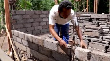 Tuğlacı inşaat alanında çalışıyor, duvarlara tuğla örüyor, ev inşa ediyor, tuğla duvar örüyor, tuğla örüyor, mala olarak çalışıyor, açık hava, özel üniformalı, profesyonel iş adamı.