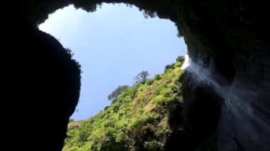 Madakaripura şelalesiyle birlikte mavi gökyüzü. Endonezya 'nın Doğu Cava kentindeki ulusal parktaki tropikal yağmur ormanlarında Güzel Madakaripura Şelalesi