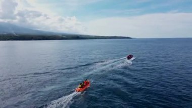 Güneşli bir günde Jet Banana Boat 'a binen turistlerle deniz manzarası. Hava takibi