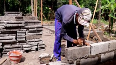 Canggu, Bali, Endonezya, 27 Mayıs 2020 tuğla ustası bir duvar örer. Bali 'de geleneksel çalışma